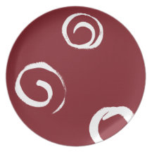 White paint swirls on red plate