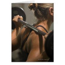 Young woman exercising with barbell, rear view greeting card