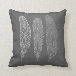 3 plumes sur le coussin gris