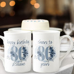 80th Birthday Cheers to 80 Years Floral Number Bone China Mug<br><div class="desc">80th birthday mug, with fully editable wording to personalize as you wish, such as "happy birthday [name]" and/or "cheers to 80 years". Design features number 80 decorated with rose buds, flower blooms and foliage in shades of coastal blue and sand. Subtle feminine and elegant design with watercolor floral arrangements, paint...</div>