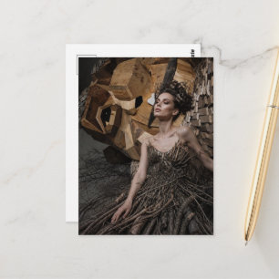 A beautiful woman in a dress made from branches postcard