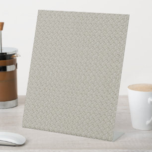 a beige background with a pattern of small squares pedestal sign