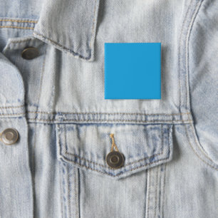 a blue background with a black and white cat 2 inch square button