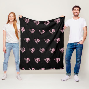 A bold black and pink filigree heart design fleece blanket