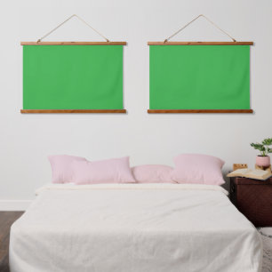 A bright green screen set against a clean white ba hanging tapestry