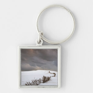 A Broken Fence Along A Snow Covered Field Keychain
