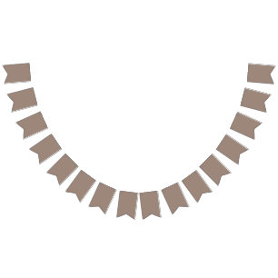 a brown wall with a clock on it bunting flags