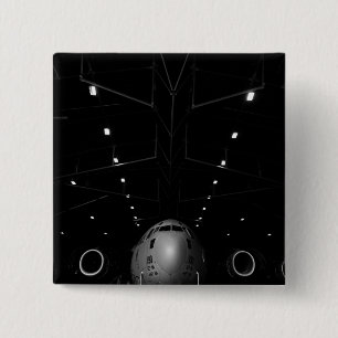 A C-17 Globemaster III sits in a hangar 2 Inch Square Button