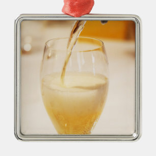 A champagne glass flute being filled with Gosset Metal Ornament