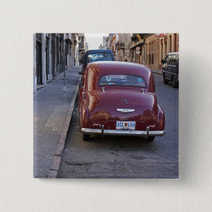 A classic old red Peugeot car parked on a street 2 Inch Square Button