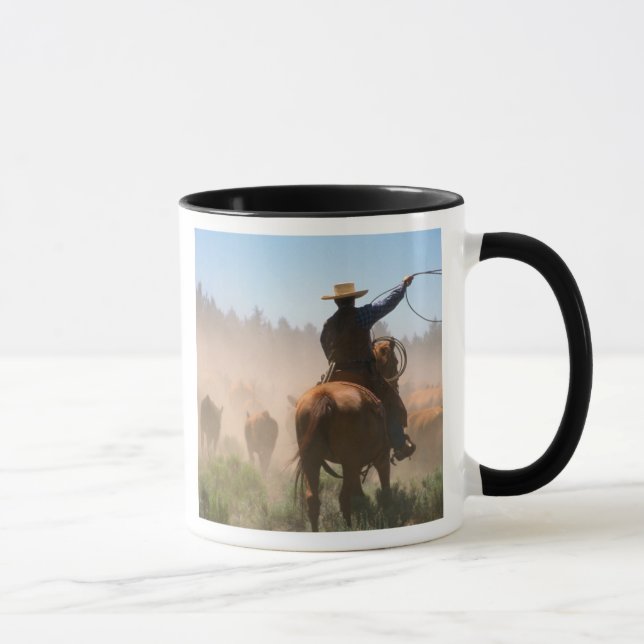 A cowboy out working the herd on a cattle mug (Right)