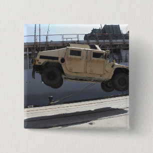 A crane lifts an M998 Humvee 2 Inch Square Button
