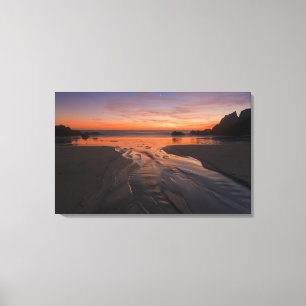 A crescent moon sets through a dusk-coloured sky canvas print