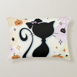 A cute pillow and a black cat. 
