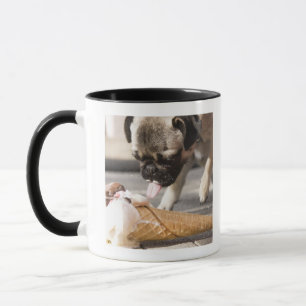 A dog eating an ice cream from a pavement mug