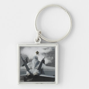 A flight deck director signals an F/A-18F Keychain