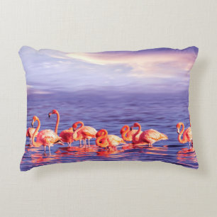 A flock of beautiful pink flamingos against a purp accent pillow