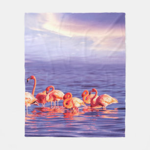 A flock of beautiful pink flamingos against a purp fleece blanket