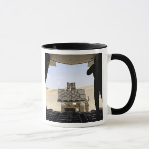 A forklift loads cargo onto a C-130 Hercules Mug