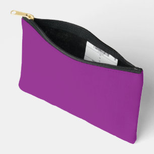A gradient background blending shades of pink and  accessory pouch