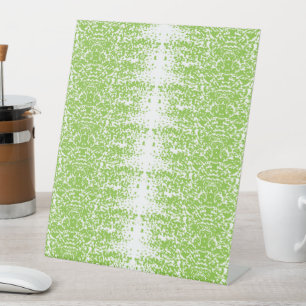 a green and white background with small dots pedestal sign