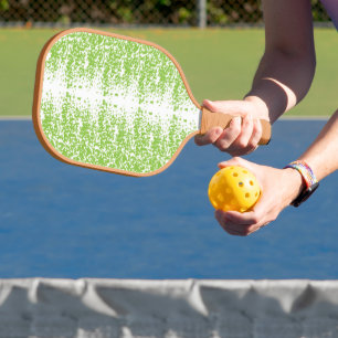 a green and white background with small dots pickleball paddle