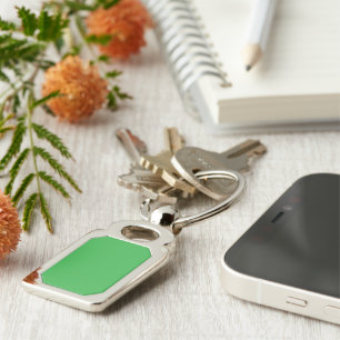 a green background with a white border keychain