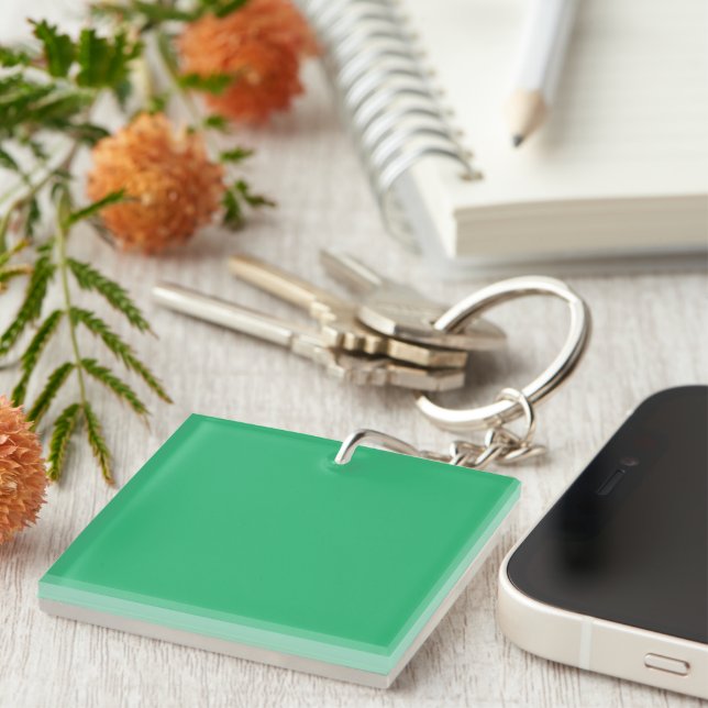 a green background with a white border keychain (Front Right)