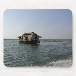 A houseboat moving placidly through a coastal lake mouse pad