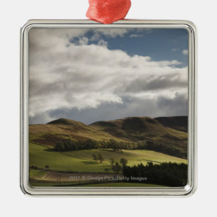 A Landscape With Rolling Hills And Clouds Overhead Metal Ornament