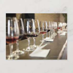 A long row of wine glasses set up so a large postcard