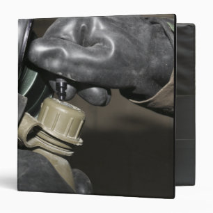 A Marine inserts a drinking tube into his cante Binder
