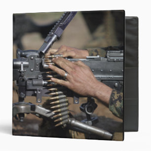 A Marine loads a M-240G machine gun Binder