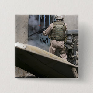 A military policeman uses a breaching round 2 inch square button