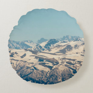 A mountain range with thawing snow and ice in the round pillow