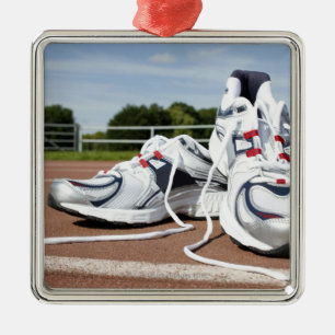 A pair of new white running trainers are placed metal ornament
