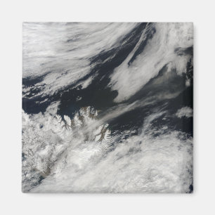 A pale grey ash plume blows from the summit magnet