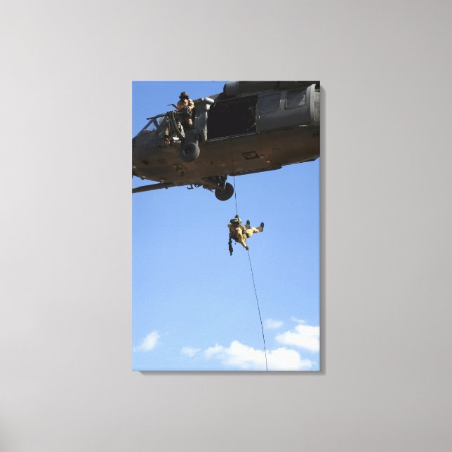 A pararescueman rappels from an HH-60 Canvas Print (Front)