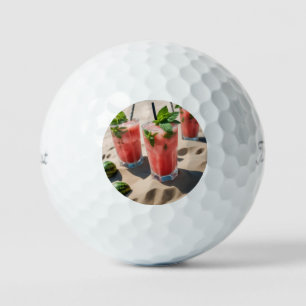 A photo of a colourful watermelon mojito with mint golf balls