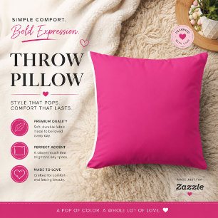 a pink background with a black throw pillow
