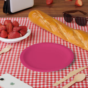 a pink background with a white border paper plate
