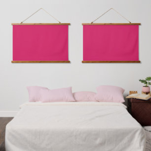 A pink square with a crisp white border, presentin hanging tapestry