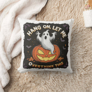 A playful ghost pondering above a jack-o'-lantern throw pillow