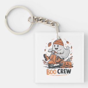 A playful ghost riding a scooter keychain