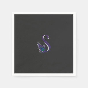 a purple and green peacock feather on a black back napkin