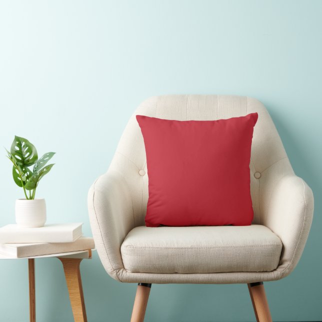 a red background with a throw pillow (Chair)