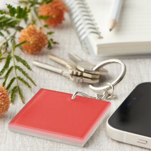 a red background with a white border keychain