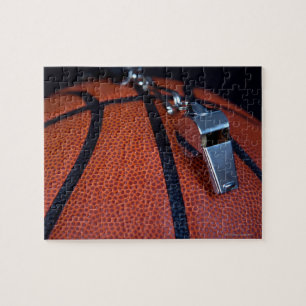 A referee's whistle rests on top of a jigsaw puzzle