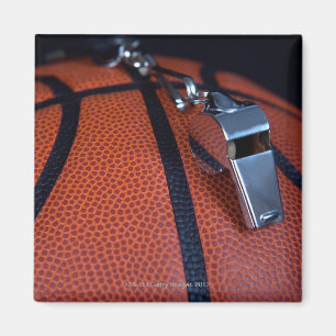 A referee's whistle rests on top of a magnet