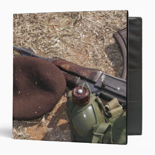 A rifle, military cover and canteen binder